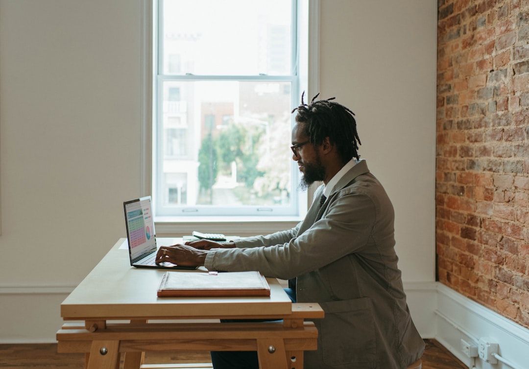 A person working at a desk with a laptop and papers