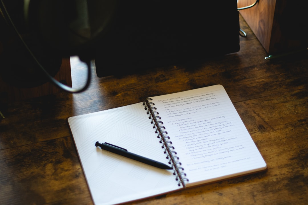 An open notebook and pen on a desk