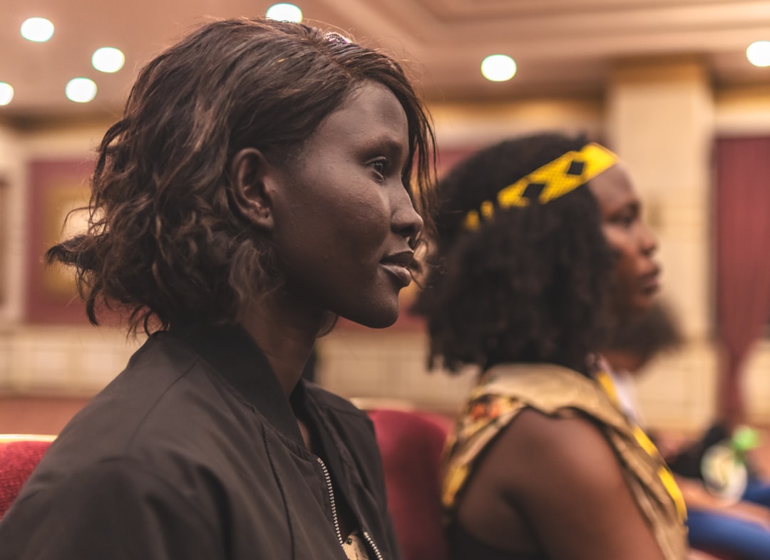 Two women are seated and looking forward.
