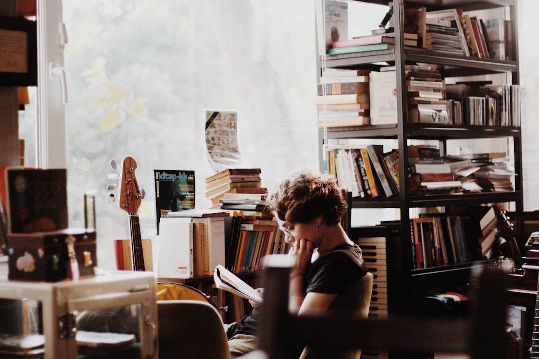 Woman reading book sitting beside electronic keyboard