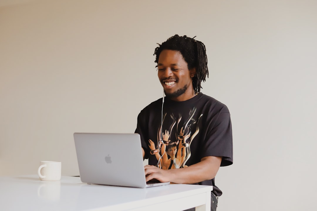 Man in black crew neck t-shirt using macbook