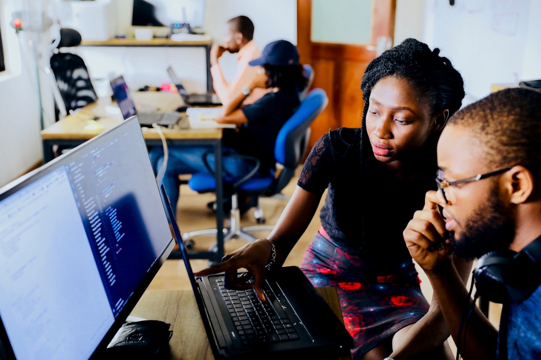 Woman and man sitting in front of monitor